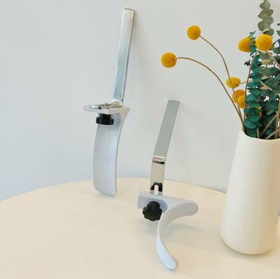 Los accesorios ginecológicos de la cama de hospital acorchetan el material blanco del ABS